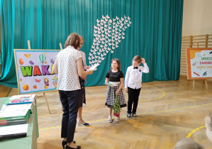 Uczniowie klasy 1b odbierają nagrody za bardzo dobre wyniki w nauce.