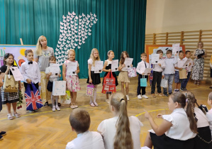 Uczniowie klas młodszych odbierają nagrody za konkurs z języka angielskiego.