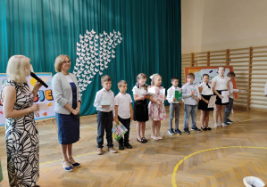 Uczniowie klasy 2b odbierają nagrody za bardzo dobre wyniki w nauce.
