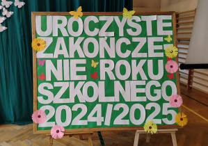 Tablica z napisem: "Uroczyste zakończenie roku szkolnego 2024 - 2025".