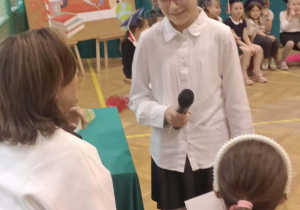 Uczennica klasy 3 prosi Panią Dyrektor o pasowanie Pierwszoklasistów na uczniów naszej szkoły.