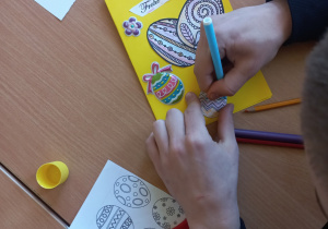 Uczniowie wykonują kartki wielkanocne w języku niemieckim na szkolny konkurs.