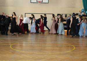 Uczniowie klas ósmych tańczą poloneza.
