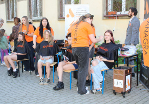 Uczniowie ze szkoły kosmetyczno - fryzjerskiej ANAGRA wykonują chętnym fryzury i makijaż.