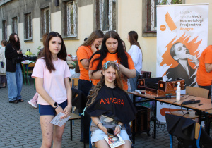 Uczniowie ze szkoły kosmetyczno - fryzjerskiej ANAGRA wykonują chętnym fryzury i makijaż.