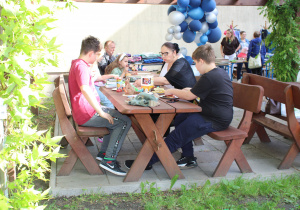 Uczestnicy pikniku przy stolikach.