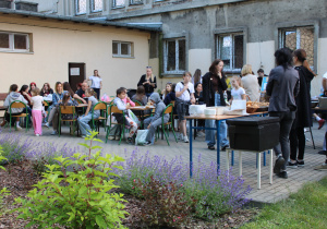 Uczestnicy pikniku przy stolikach.