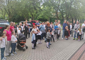 Powitanie uczniów klasy pierwszej przed budynkiem szkoły.