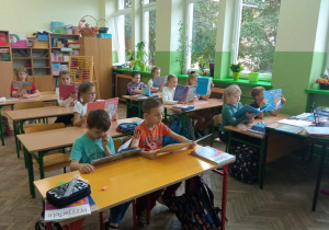 Uczniowie klasy 3a czytają podczas przerwy.