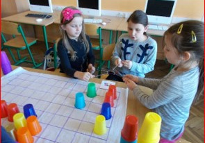 Zajęcia w ramach Europejskiego Tygodnia Kodowania. Dzieci programują kolorowe kubeczki.